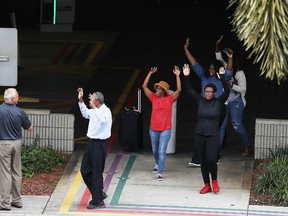 People seeking cover walk towards police with their arms raised outside of Fort Lauderdale-Hollywood International airport after a shooting took place near the baggage claim on January 6, 2017 in Fort Lauderdale, Florida.  (Photo by Joe Raedle/Getty Images)