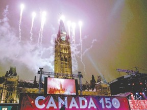 Fireworks light up the sky behind the Peace Tower during a New Year?s Eve celebration on Parliament Hill on Dec. 31 in Ottawa. (Canadian Press file photo)