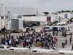 People stand on the tarmac at the Fort Lauderdale-Hollywood International Airport after a shooter opened fire inside a terminal of the airport, killing several people and wounding others before being taken into custody, Friday, Jan. 6, 2017, in Fort Lauderdale, Fla. WILFREDO LEE / AP