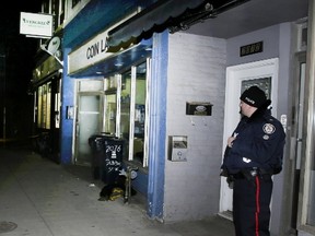 A police officer stands outside Evergreen Medicinals on Friday. (VERONICA HENRI, Toronto Sun)