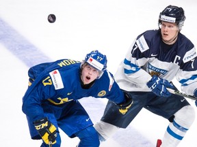 Sweden's Fredrik Karlstrom, left, and Finland's Olli Juolevi keep their eyes on the puck during first period IIHF World Junior Championship hockey action Thursday, December 29, 2016 in Montreal. (THE CANADIAN PRESS/Paul Chiasson)