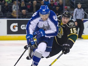 London Knights? Cole Tymkin falls but manages to poke the puck away from Chandler Yakimowicz of the Sudbury Wolves during the first period of their OHL game at Budweiser Gardens on Friday night. The Knights fell behind 4-2 in the third period but came back to win 5-4 in overtime. (DEREK RUTTAN, The London Free Press)