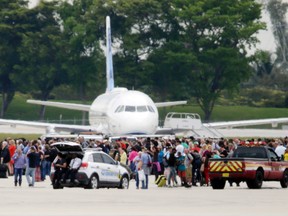 People stand on the tarmac at the Fort Lauderdale-Hollywood International Airport after a shooter opened fire inside a terminal of the airport, killing five people and wounding eight before being taken into custody, Friday.
Lynne Sladky /AP Photo