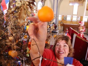 Zandra Zubac decorates the Badnjak (oak) tree in preparation for the blessing of the Badnjak at a Christmas Eve service at Sts. Peter and Paul Serbian Orthodox Church in Sudbury, Ont. on Friday January 6, 2017. John Lappa/Sudbury Star/Postmedia Network