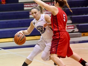 Kayla Deschatelets, left, of Laurentian Voyageurs, drives to the basket against Bridget Atkinson, of the Brock Badgers, during women's basketball action at Laurentian University in Sudbury on Friday evening. John Lappa/Sudbury Star/Postmedia Network