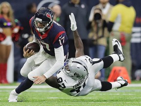 Texans quarterback Brock Osweiler (17) scrambles for a first down against Raiders defensive end Mario Edwards (97) during first half AFC Wild Card action in Houston on Saturday, Jan. 7, 2017. (Eric Gay/AP Photo)