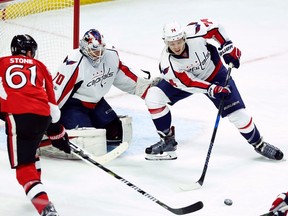 Senators’ Mark Stone tries to reach for a loose puck in front of Washington Capitals’ John Carlson and goalie Braden Holtby during last night’s game. (THE CANADIAN PRESS)