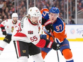 Senators' Erik Karlsson (65) gets the shot off as Oilers' Connor McDavid (97) gives chase during first period NHL action in Edmonton on Oct. 30, 2016. (Jason Franson/The Canadian Press)