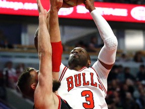 Chicago Bulls guard Dwyane Wade, right, shoots over Toronto Raptors centre Jonas Valanciunas during the overtime of an NBA basketball game Saturday, Jan. 7, 2017, in Chicago. The Bulls won 123-118 in overtime. (AP Photo/Nam Y. Huh)