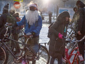 Participants of the second winter cycling marathon in support of cycling infrastructure in the city, one of them wearing a Ded Moroz (Santa Claus, or Father Frost) costume, prepare to ride along the embankment of the frozen Moskva River and the Kremlin Wall in Moscow, Russia, Sunday, Jan. 8, 2017. (AP Photo/Alexander Zemlianichenko Jr)