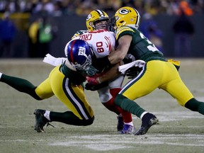 Jake Ryan and Micah Hyde of the Green Bay Packers tackle Victor Cruz of the New York Giants in the second quarter during the NFC Wild Card game at Lambeau Field on January 8, 2017 in Green Bay, Wisconsin. (Jonathan Daniel/Getty Images)