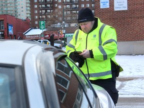 Parking-enforcement officer Sean Steenbergen tickets a car on Clarence Street in London. (DALE CARRUTHERS, The London Free Press)