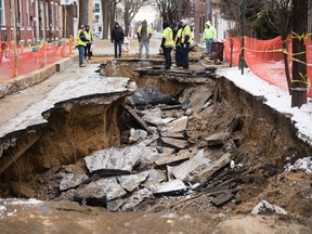 Workers inspect a sinkhole in Philadelphia, Monday, Jan. 9, 2017. The Philadelphia Water Department said a water main break caused the sinkhole to open up on the street. (AP Photo/Matt Rourke)