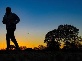 In this Tuesday, Nov. 22, 2016 file photo, a runner is silhouetted against the sunrise on his early morning workout near Arlington National Cemetery in Arlington, Va., across the Potomac River from the nation's capital. Research released on Monday, Jan. 9, 2017 suggests that people who pack their workouts into one or two days a week lower their risk of dying as much as those who exercise more often, as long as they get enough of it. (AP Photo/J. David Ake)