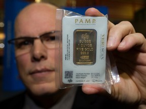 Cst. Robert Wellon with the EPS Northwest Division's Criminal Investigation Section holds a counterfeit gold bar being sold in the city, during a press conference at EPS headquarters in Edmonton Monday Jan. 9, 2017. DAVID BLOOM/Postmedia