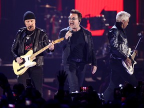 In this Sept. 23, 2016, file photo, The Edge, from left, Bono and Adam Clayton of the music group U2 perform at the 2016 iHeartRadio Music Festival at T-Mobile Arena in Las Vegas. U2 announced Jan. 9, 2017, that it will play the entirety of its classic 1987 album “The Joshua Tree” at each stop during a summer stadium tour to celebrate the 30th anniversary of its release. (Photo by John Salangsang/Invision/AP, File)