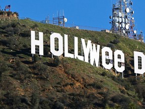 In this Jan. 1, 2017, file photo, the famed Hollywood sign is seen altered to read "HOLLYWeeD," in Los Angeles. Los Angeles police said in a statement that 30-year-old Zachary Cole Fernandez was arrested Monday, Jan. 9, 2017, in connection with the vandalism. Police say Fernandez turned himself in with his attorney and was booked on suspicion of misdemeanor trespassing. (AP Photo/Damian Dovarganes, File)