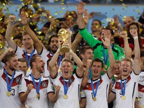 In this July 13, 2014 file photo, Germany's Bastian Schweinsteiger holds up the World Cup trophy as the team celebrates their 1-0 victory over Argentina after the World Cup final soccer match between Germany and Argentina at the Maracana Stadium in Rio de Janeiro, Brazil. FIFA is about to make the World Cup a bigger and, it hopes, richer event. (AP Photo/Natacha Pisarenko, file)
