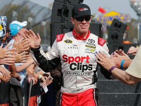 In this Oct. 30, 2016, file photo, Sprint Cup Series driver Carl Edwards greets fans during driver introductions for the NASCAR Sprint Cup auto race at Martinsville Speedway in Martinsville, Va. (AP Photo/Steve Helber, File)