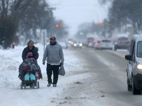 People walk on the road on Mountain Avenue earlier this winter, due to snow on the sidewalks. The promptness, or lack thereof, of city sidewalk snow plowing has caused some consternation amongst Winnipeg residents. But city officials say they're proud of their efforts this winter. (CHRIS PROCAYLO/WINNIPEG SUN FILE PHOTO)