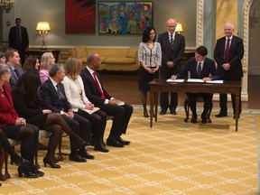 Minister of Foreign Affairs Chrystia Freeland, Minister of Labour Patty Hajdu, Minister of Status of Women Maryam Monsef, Minister of International Trade Francois-Philippe Champagne, Minister of Democratic Institutions Karina Gould and Minister of Immigration, Refugees and Citizenship Ahmed Hussen look on as Prime Minister Justin Trudeau and Governor General David Johnston sign documents during a cabinet shuffle at Rideau Hall in Ottawa, Tuesday, Jan. 10, 2017. THE CANADIAN PRESS/Adrian Wyld