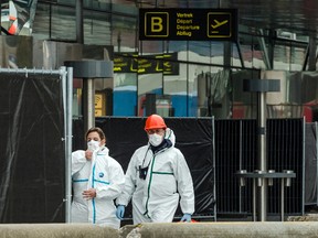 Forensics officers work in front of the damaged Zaventem Airport terminal in Brussels on Wednesday, March 23, 2016. (AP Photo/Geert Vanden Wijngaert, Pool)