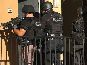 Law enforcement officers conduct a door-to-door search at an apartment complex in Orlando, Fla., Monday, Jan. 9, 2017. (Stephen M. Dowell/Orlando Sentinel via AP)
