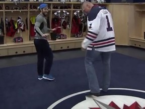 Brock Lesnar steps over a team logo inside the Winnipeg Jets locker room (YouTube screen grab)