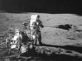 In this Feb. 13, 1971 file photo, Apollo 14 astronaut Alan B. Shepard Jr. conducts an experiment near a lunar crater, using an instrument from a two-wheeled cart carrying various tools. On Wednesday, Jan. 11, 2017, a California-led research team reported that the moon formed within 60 million years of the birth of the solar system. Previous estimates ranged within 100 million years, all the way out to 200 million years of the solar system’s creation. (NASA via AP)