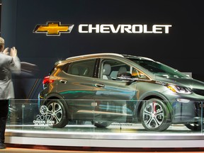 A man takes a photo of the Chevrolet Bolt at the 2017 North American International Auto Show in Detroit, Michigan, January 10, 2017. (GEOFF ROBINS/AFP/Getty Images)