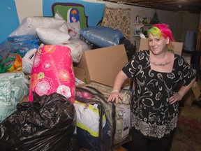 Jennifer Whitehead with a large pile of stuff collected for neighbours that were burned out of their home. (DEREK RUTTAN, The London Free Press)