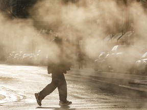 A pedestrian crosses 104 Street near 102 Avenue on a cold afternoon in downtown Edmonton, Alberta on Saturday, December 17, 2016. Ian Kucerak / Postmedia