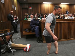 Oscar Pistorius's prosthetics lie on the floor as he walks on his amputated legs during argument in mitigation of sentence by his defense attorney Barry Roux in the High Court in Pretoria, South Africa, on June 15, 2016. (Siphiwe Sibeko via AP, Pool, File)