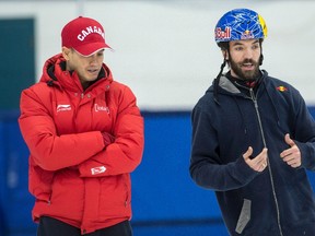 Charles Hamelin (right) talks with coach Derrick Campbell during a short-track speedskating practice in Montreal on Wednesday, Jan. 11, 2017. (Paul Chiasson/The Canadian Press)