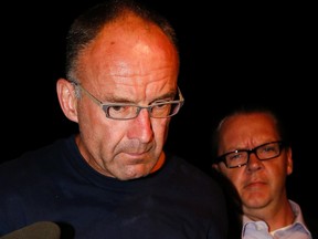 Douglas Garland is escorted by Calgary Police Service detectives to the arrest processing unit in Calgary, Alta., on Monday July 14, 2014.
Mike Drew/Calgary Sun