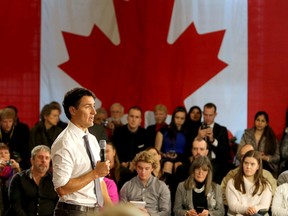 Prime Minister Justin Trudeau speaks in front of a Canadian flag during his town hall meeting with about 265 people in Memorial Hall in Kingston's City Hall on Thursday January 12 2017.  Ian MacAlpine /The Whig-Standard/Postmedia Network