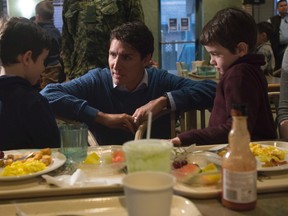 Adrian Wyld/Canadian Press
Prime Minister Justin Trudeau speaks with two brothers as he visits the base mess hall at CFB Trenton in Trenton, Friday. Trudeau’s visit to Belleville on Thursday evening resulted in hundreds being turned away due to a larger crowd than had been anticipated.