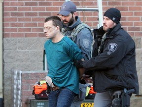 Kingston Police lead away a man accused of assault with a weapon, arson and weapons dangerous, after police and Kingston Fire and Rescue and Frontenac Paramedic Service responded to 257 Rideau St in Kingston, Ont. on Friday January 13, 2017.   Steph Crosier/Kingston Whig-Standard/Postmedia Network