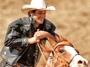 Ty Pozzobon takes a victory lap after winning the day money in the bull riding event during the Calgary Stampede rodeo in Calgary on July 9, 2014. (Al Charest/Calgary Sun)