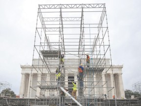 Construction workers climb scaffolding erected for the presidential inauguration in Washington, D.C. on Friday. (ANDREW CABALLERO-REYNOLDS/AFP/Getty Images)