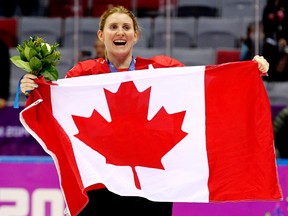 Team Canada's Hayley Wickenheiser celebrates with a Canadian flag after beating Team USA 3-2 in overtime to win the women's ice hockey gold medal at the Bolshoy Ice Dome during the Sochi Winter Olympics in Sochi, Russia, on Feb. 20, 2014. Wickenheiser announced her retirement from the national team on Friday, Jan. 13, 2017. (Al Charest/Postmedia Network/Files)