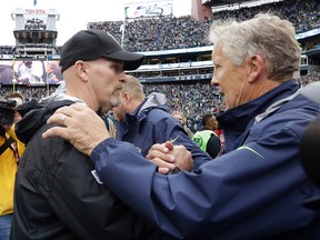 In this Oct. 16, 2016, file photo, Seattle Seahawks coach Pete Carroll, right, greets Atlanta Falcons coach Dan Quinn after an NFL football game in Seattle. (AP Photo/Elaine Thompson, File)