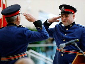 Edmonton Police Service Constable Scott Bailey (right) salutes police chief Rod Knecht after graduating from police recruit training class 136 at Edmonton City Hall on Friday Jan. 13, 2017.