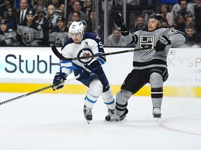 Winnipeg Jets center Mark Scheifele, left, and Los Angeles Kings center Trevor Lewis battle for the puck during the first period of an NHL hockey game, Saturday, Jan. 14, 2017, in Los Angeles. (AP Photo/Mark J. Terrill)