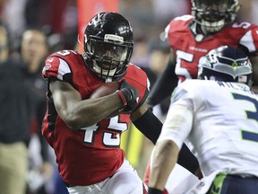 Atlanta Falcons linebacker Deion Jones intercepts a throw by Seattle Seahawks quarterback Russell Wilson, who tries to make the tackle, in the final minutes of an NFL football NFC divisional playoff game on Saturday, Jan. 14, 2017, in Atlanta. (Curtis Compton/Atlanta Journal-Constitution via AP)