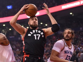 Toronto Raptors center Jonas Valanciunas grabs a rebound as New York Knicks forward Lance Thomas and center Joakim Noah look on during first half NBA basketball action in Toronto on Sunday, January 15, 2017. (THE CANADIAN PRESS/Frank Gunn)