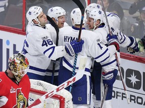 Senators goaltender Mike Condon bows his head as Maple Leafs players celebrate their final goal of a 4-2 victory at the Canadian Tire Centre on Saturday. (Wayne Cuddington/Postmedia Network)