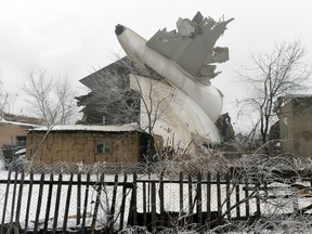 The tail of a crashed Turkish Boeing 747 cargo plane lies at a residential area outside Bishkek, Kyrgyzstan, Monday, Jan. 16, 2017. The cargo plane crashed Monday morning, killing people in the residential area adjacent to the Manas airport as well as those on the plane. (AP Photo/Vladimir Voronin)