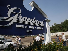 Fans walk by the entrance to Graceland, the home of Elvis Presley, 14 August 2007, in Memphis, Tennessee.  (STAN HONDA/AFP/Getty Images)