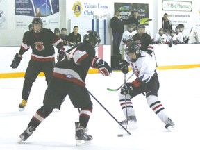 Vulcan bantam Hawk Scott Donovan is met by an opposing Siksika Warrior player as he makes his way to Siksika’s goal during a game Friday evening at the Vulcan District Arena.